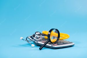 Stethoscope and magnifying glass on a calculator, set against a blue background.